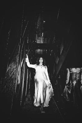 dramatic vantablack architectural ballgown flowing elegantly on a grand staircase.