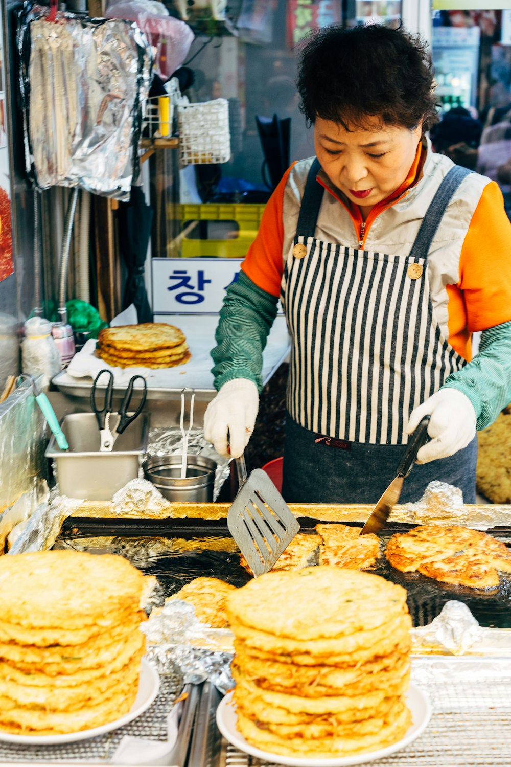 woman in white apron holding black spatula