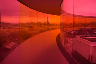 Panoramic elevator with glass walls offering a cityscape view.