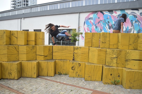 Group of parkour students practicing vaults over obstacles of varying heights.