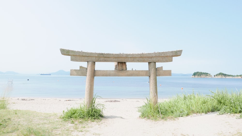 brown wooden stand on white sand near body of water during daytime