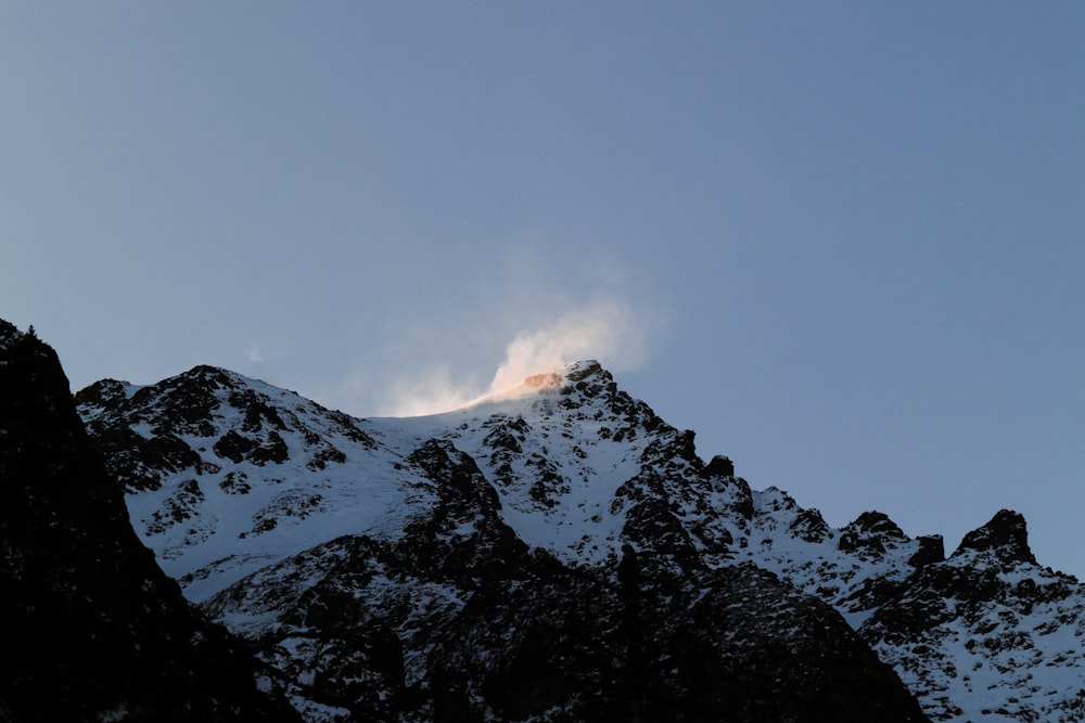 snow covered mountain under gray sky