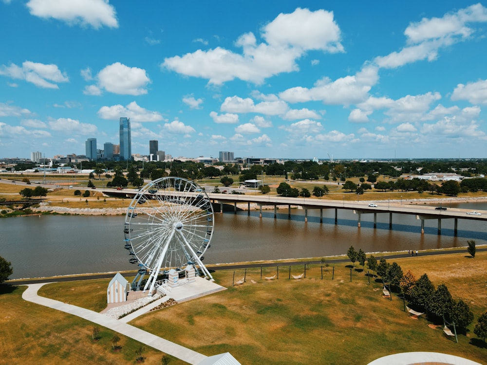 white ferris wheel near body of water under blue sky during daytime