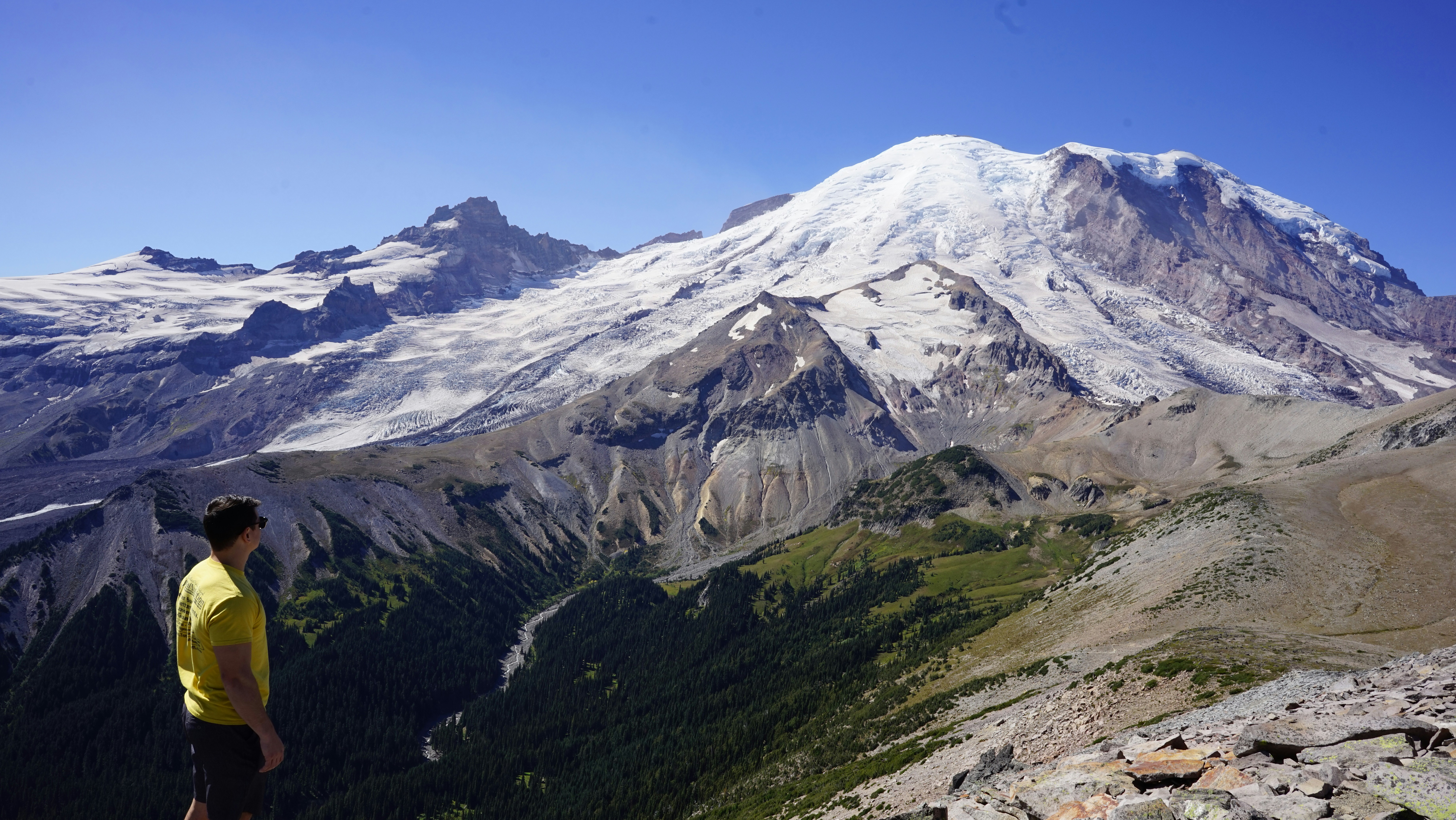 green grass and white snow covered mountain under blue sky during daytime