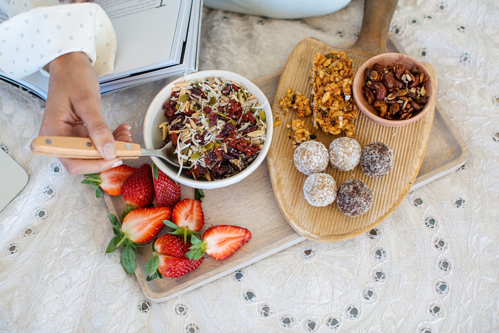 strawberries and nuts on brown wooden chopping board