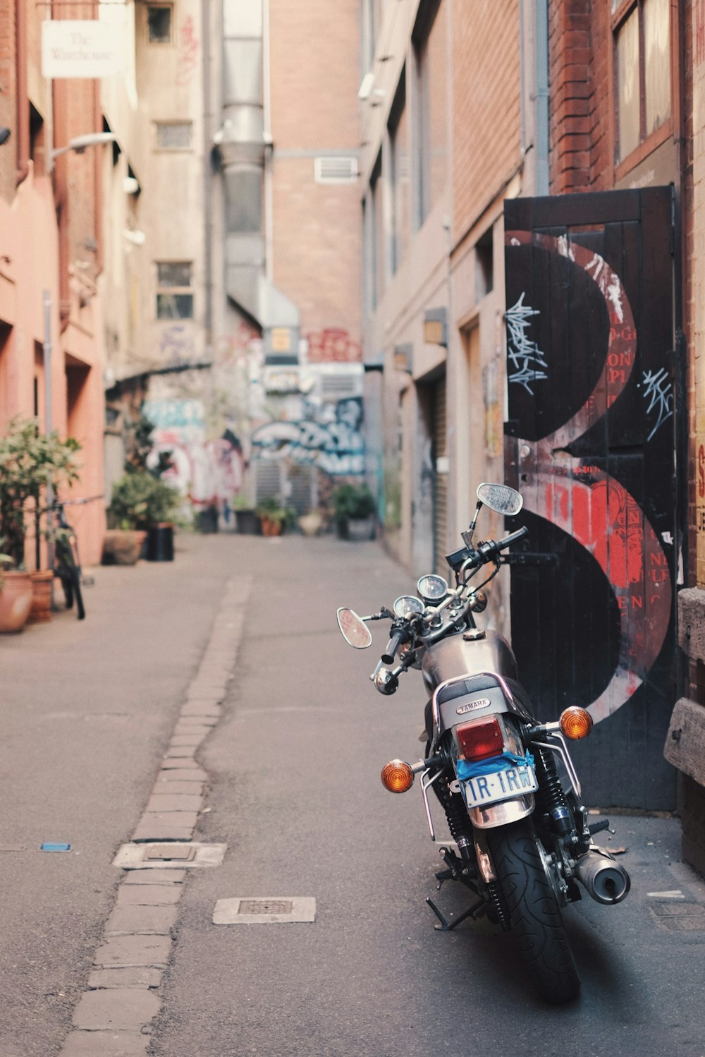 black motorcycle parked beside wall