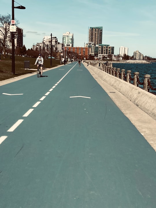 people walking on sidewalk near body of water during daytime in Burlington Canada