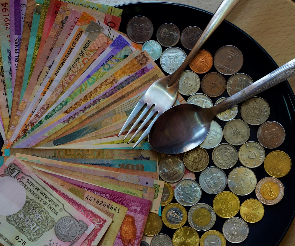 silver and gold coins on top of multi colored textile