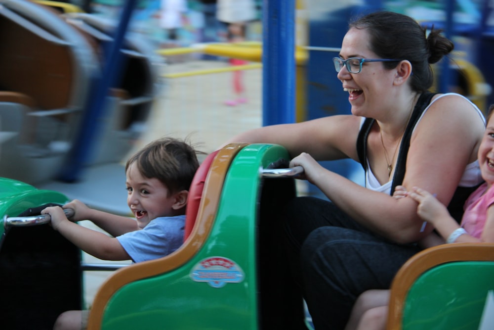 woman in black tank top wearing black framed eyeglasses sitting on green and yellow plastic slide