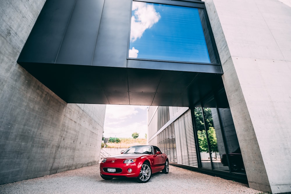 red car parked beside building