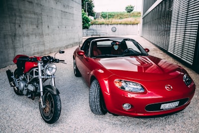 red ferrari car parked beside gray concrete wall mazda google meet background