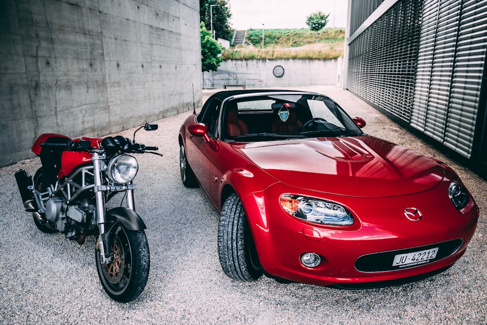 red ferrari car parked beside gray concrete wall