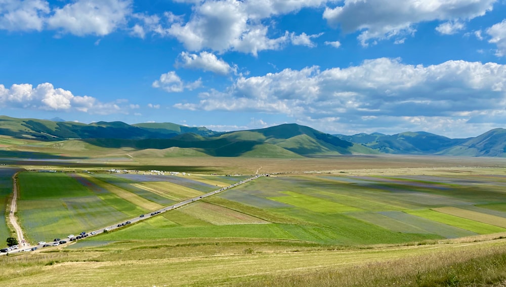 Grünes Grasfeld unter blauem Himmel tagsüber