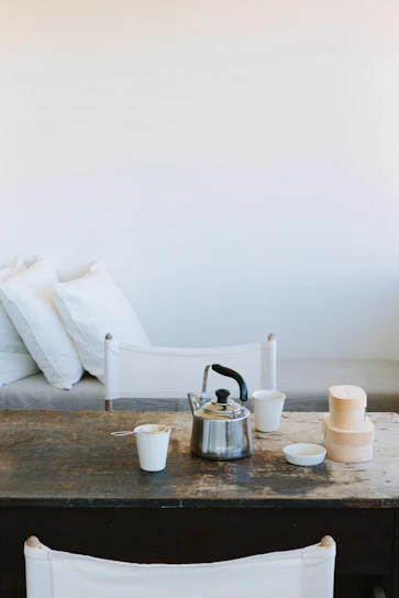 A serene, minimalist setup showcasing a ceramic pet bowl and silicone mat on a warm beige floor with soft natural light.