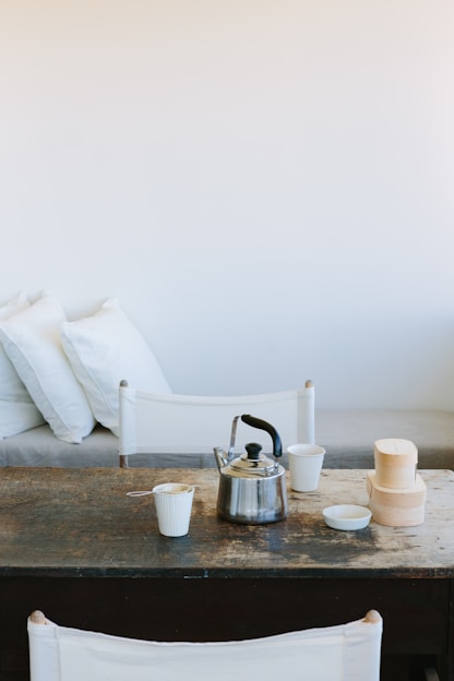 A cozy kitchen scene featuring minimalist ceramic bowls and plates arranged on a wooden table.