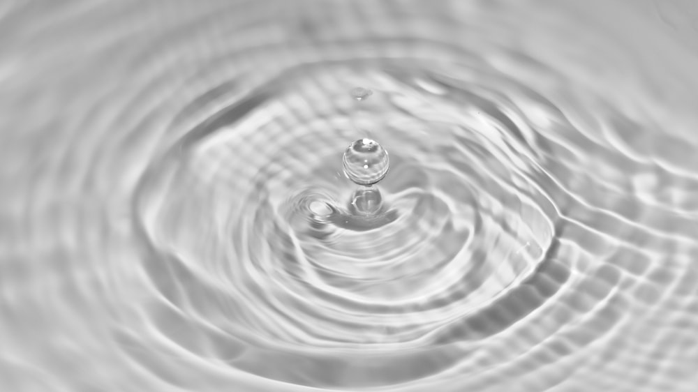 water drop in grayscale photography