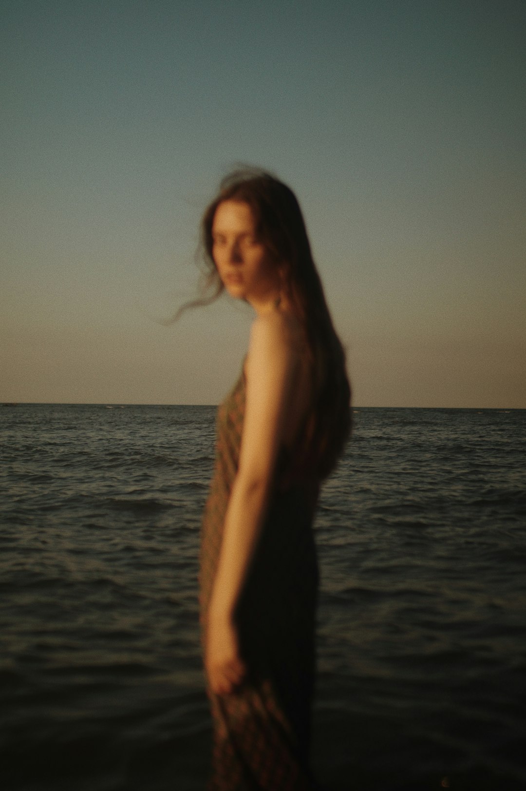 woman in black dress standing on beach during daytime