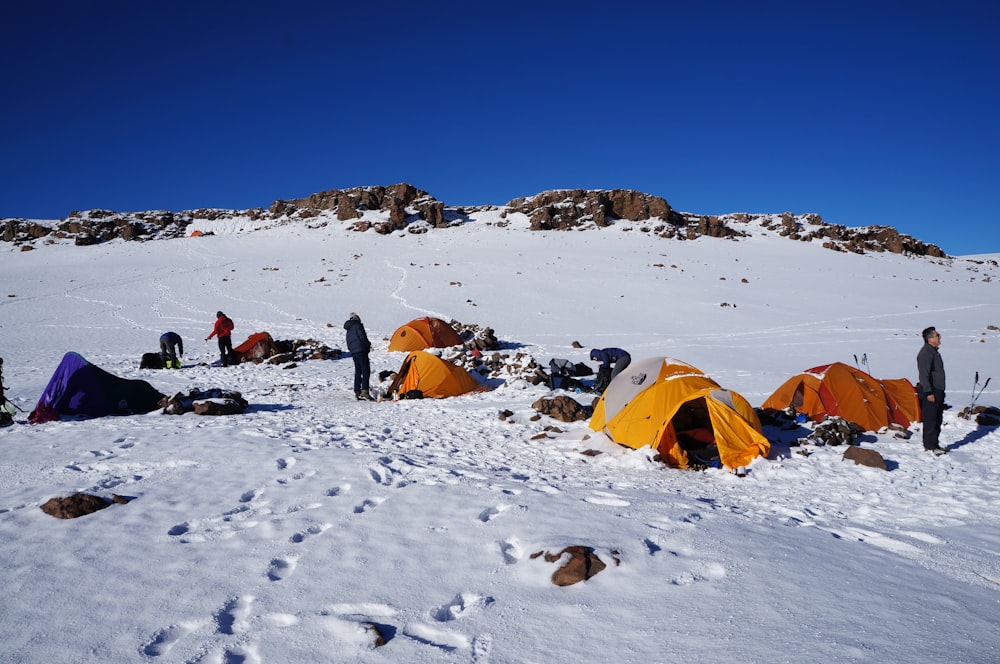 people sitting on snow covered ground during daytime