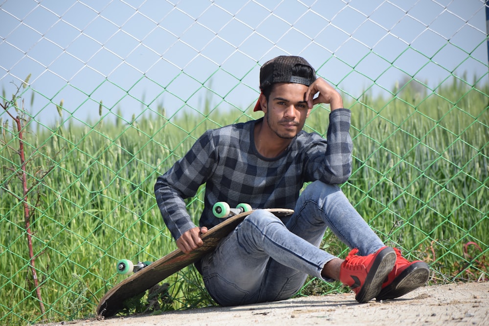 boy in black and gray plaid dress shirt and blue denim jeans sitting on brown wooden