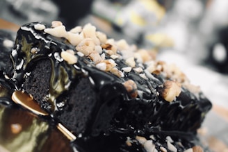 A close-up of a rich chocolate cake with glossy ganache and fresh berries on top.