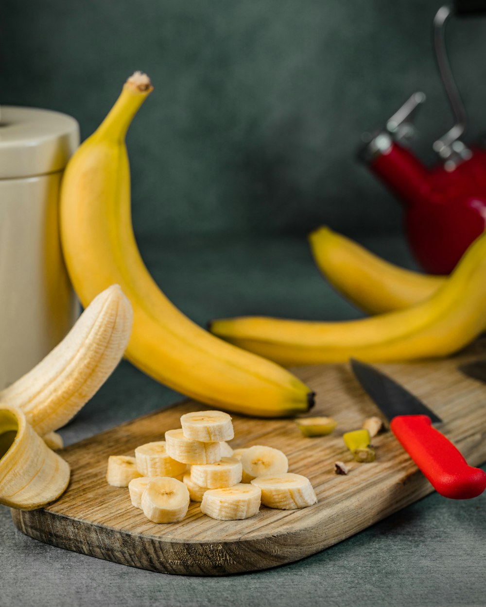 yellow banana fruit on brown wooden chopping board