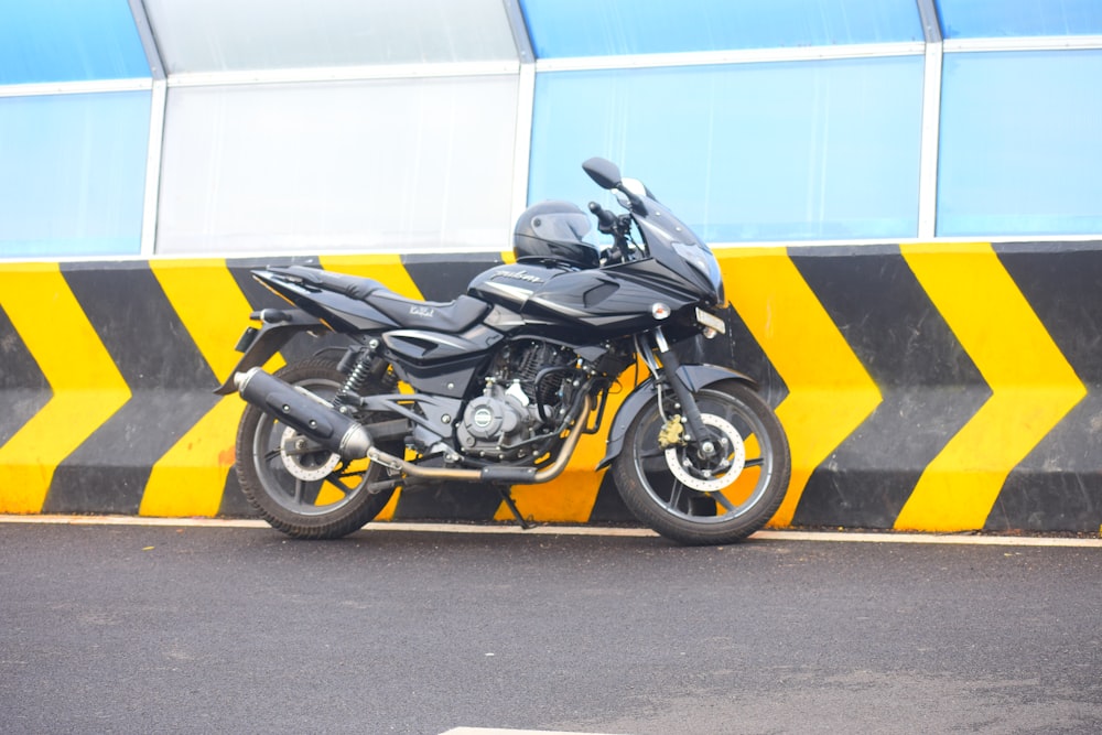 yellow and black sports bike parked beside white wall