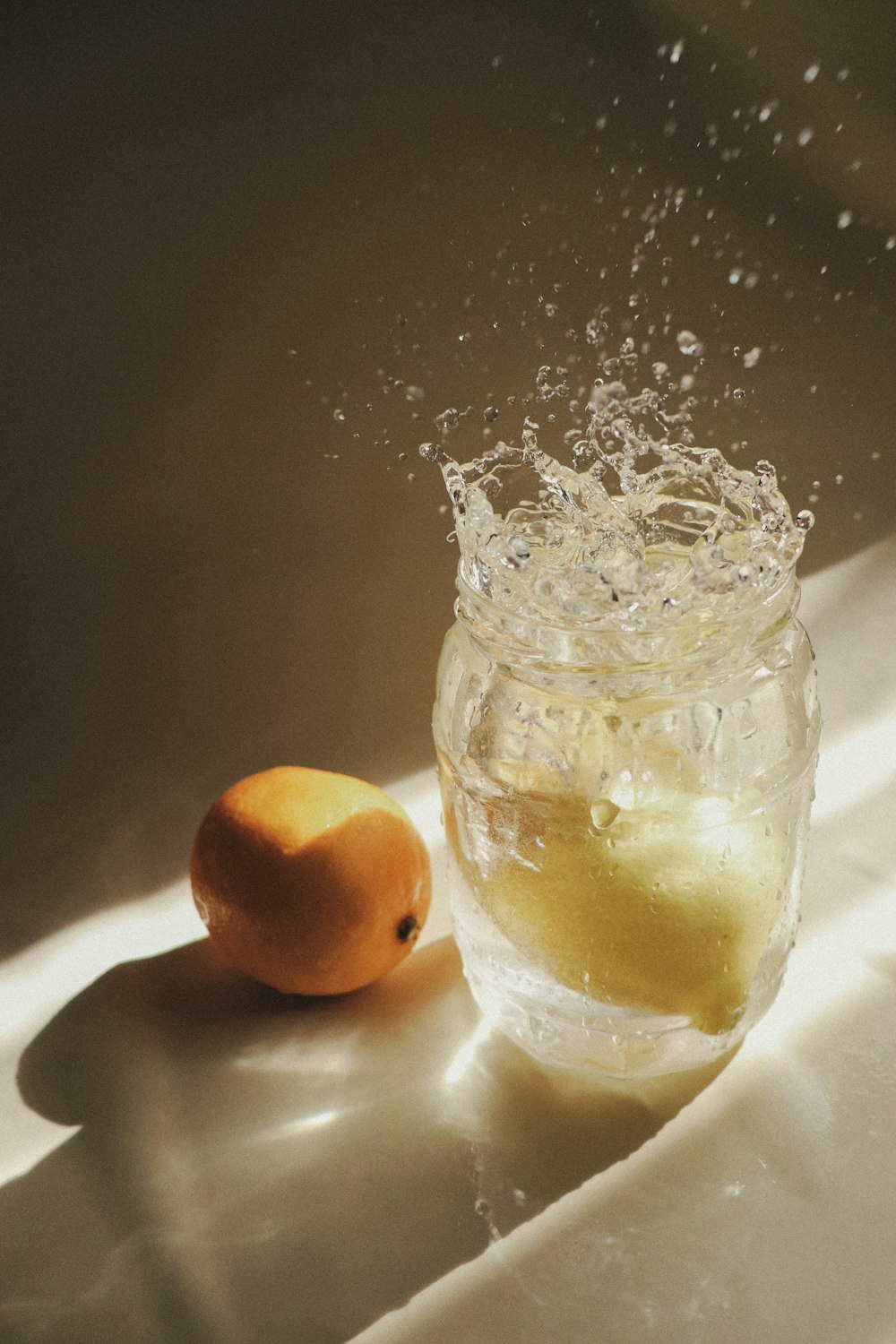 two orange fruits in clear glass jar