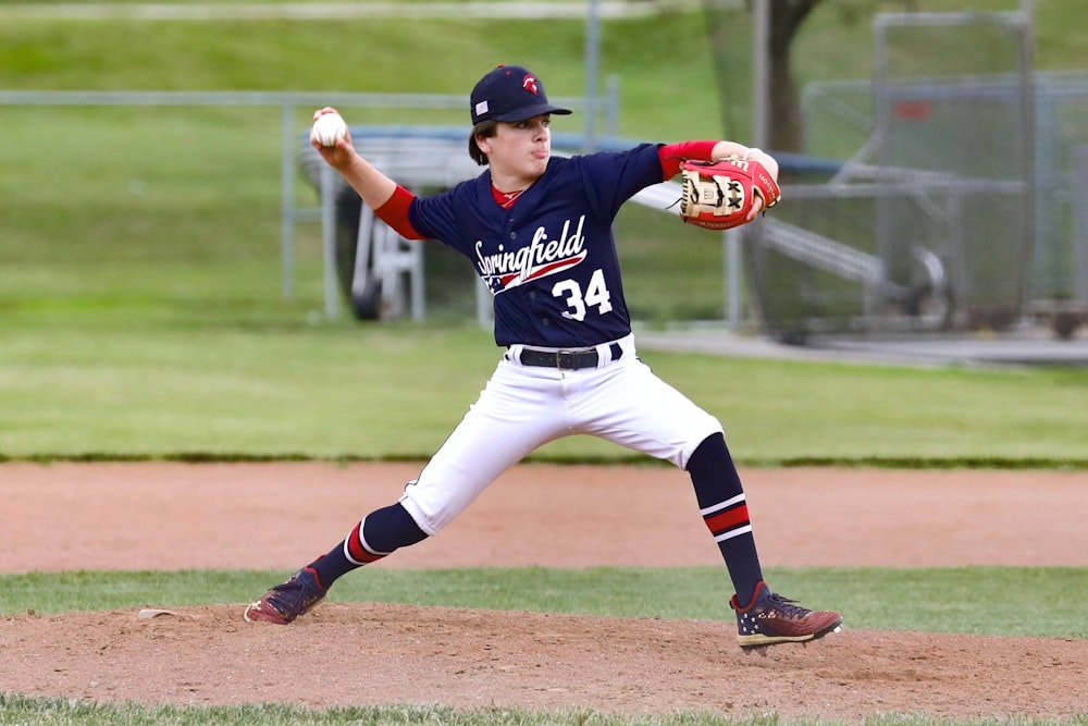 Mann in blau-weißem Trikothemd und weißer Hose mit Baseballschläger