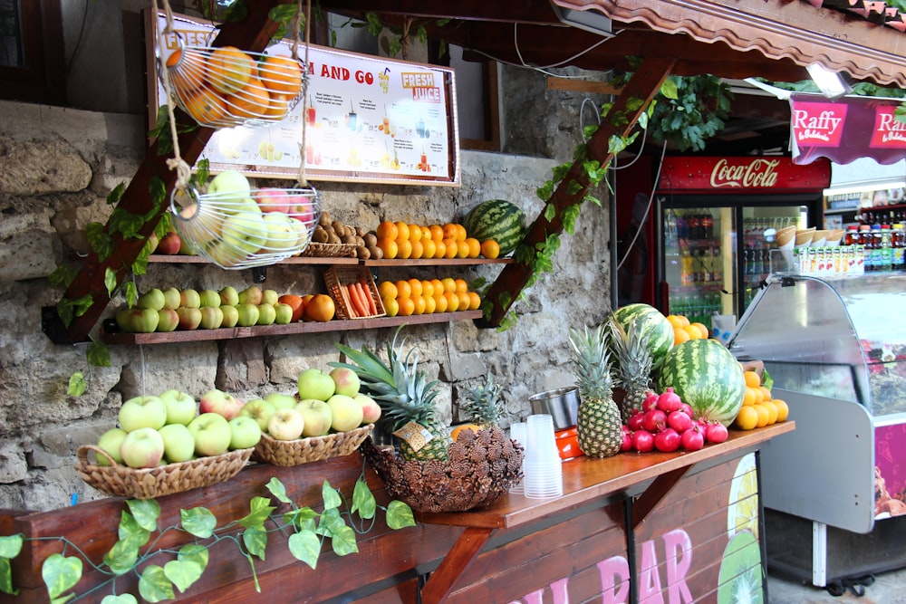 green and yellow fruits on brown wooden shelf