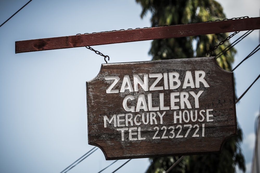 brown wooden hanging signage during daytime