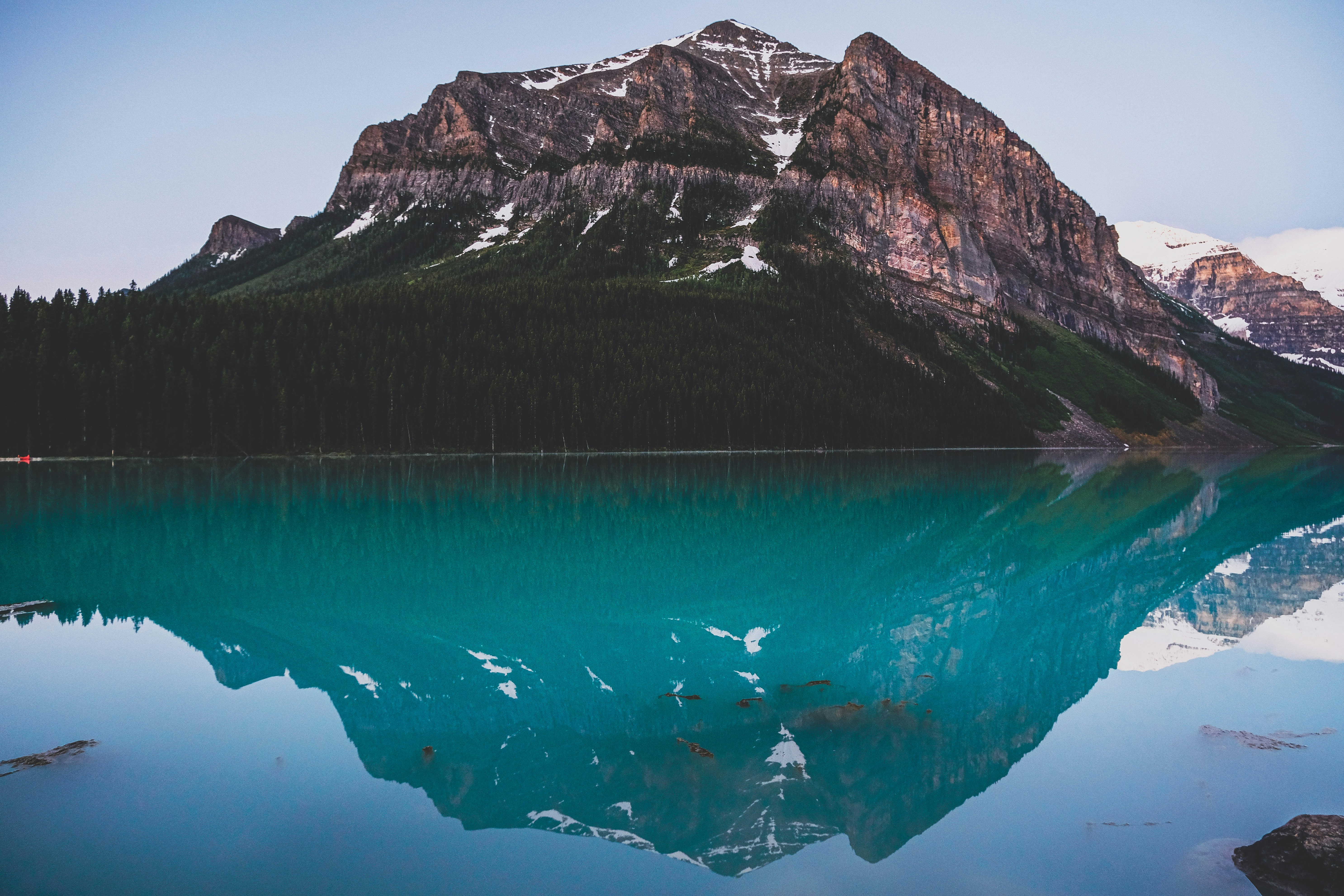 blue water near gray and white mountain during daytime