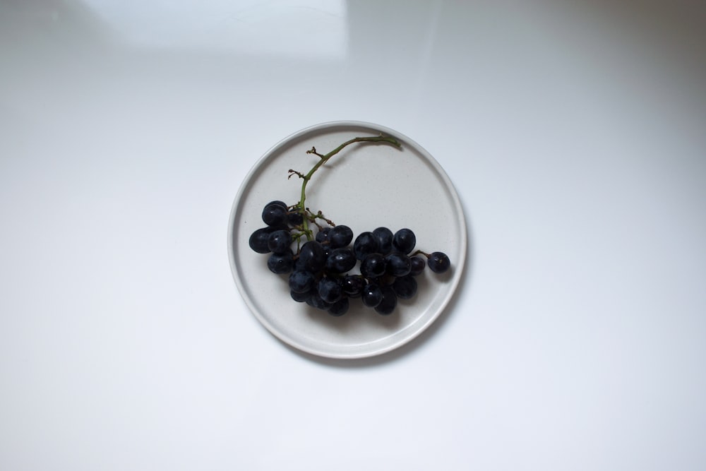 black berries on white ceramic plate