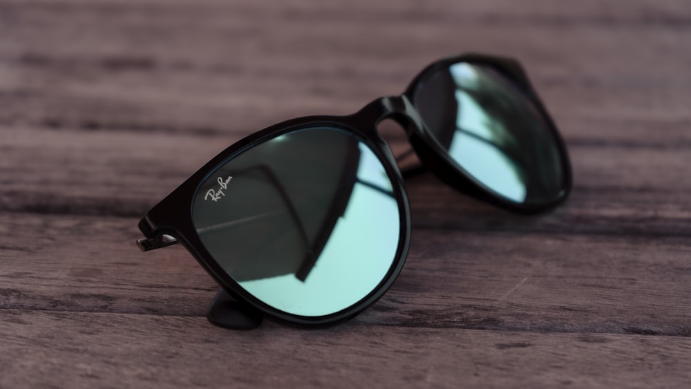 black framed sunglasses on brown wooden table