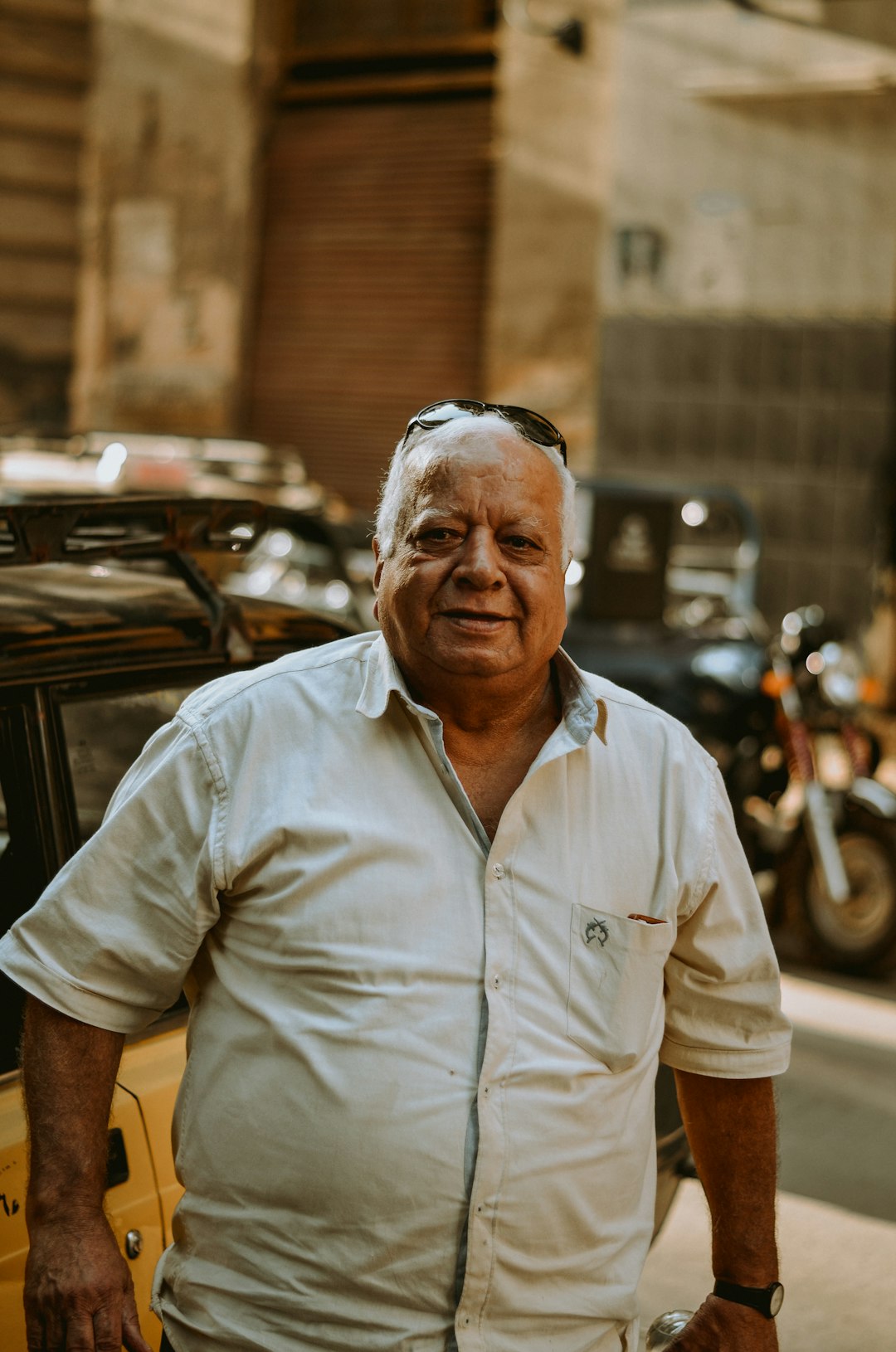 man in white button up shirt standing near black motorcycle during daytime