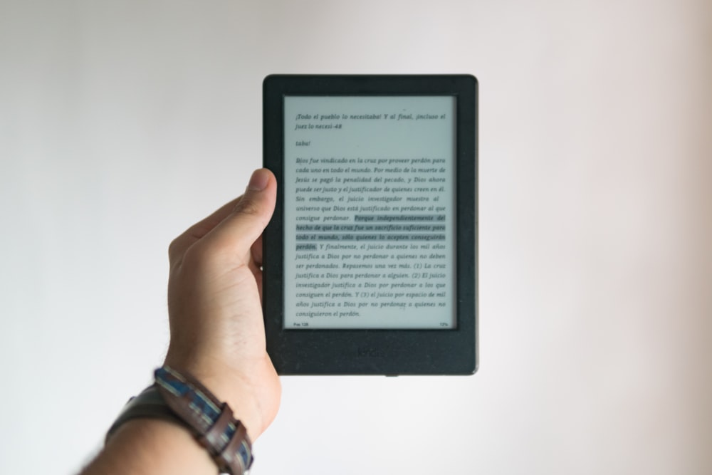 person holding black e book reader