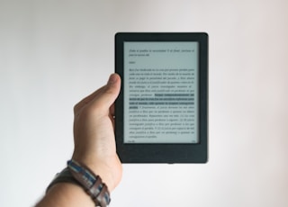 person holding black e book reader