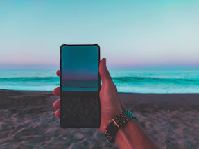 Modern contact form interface on a sleek smartphone screen with beach house background