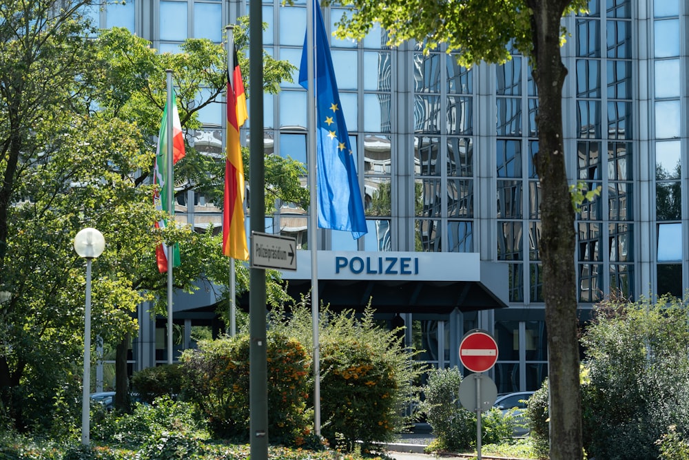 flags on poles near building during daytime