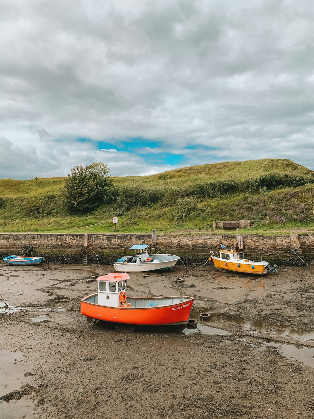 red and white boat on brown sand during daytime