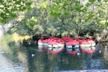 A group of people riding rented pedal boats on a lake.