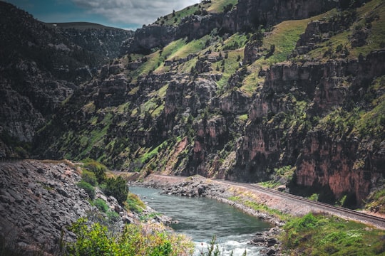 river between rocky mountains under cloudy sky during daytime in Ten Sleep United States