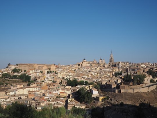 white and brown concrete houses under blue sky during daytime in Toledo Spain