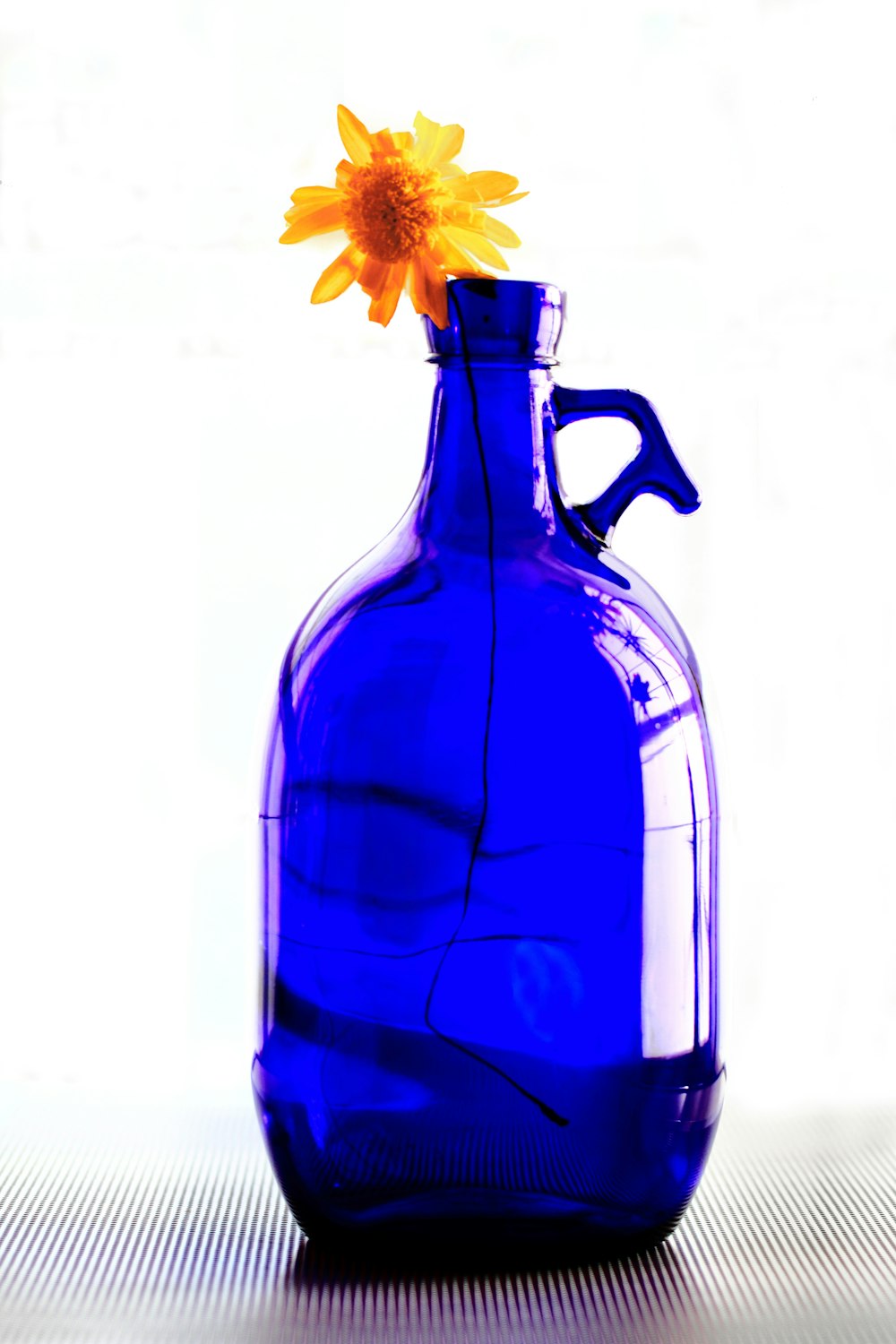 blue glass bottle with yellow flower