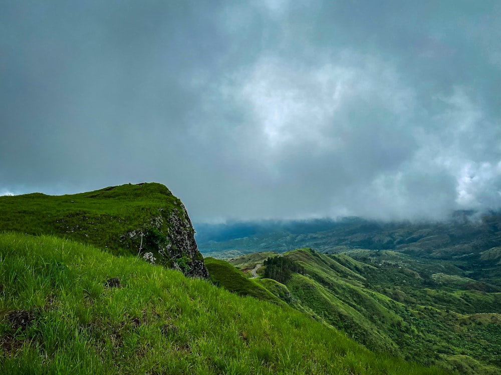 green grass field under white clouds