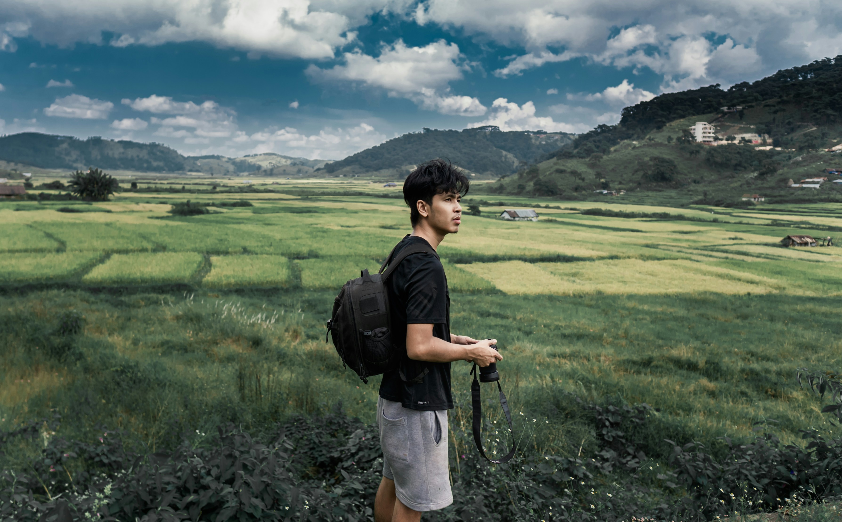 man in black t-shirt and white shorts standing on green grass field during daytime