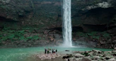 people standing near waterfalls during daytime