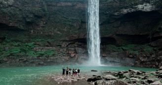 people standing near waterfalls during daytime