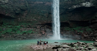 people standing near waterfalls during daytime