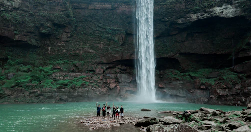 people standing near waterfalls during daytime