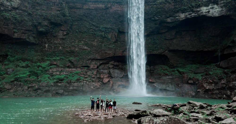 people standing near waterfalls during daytime